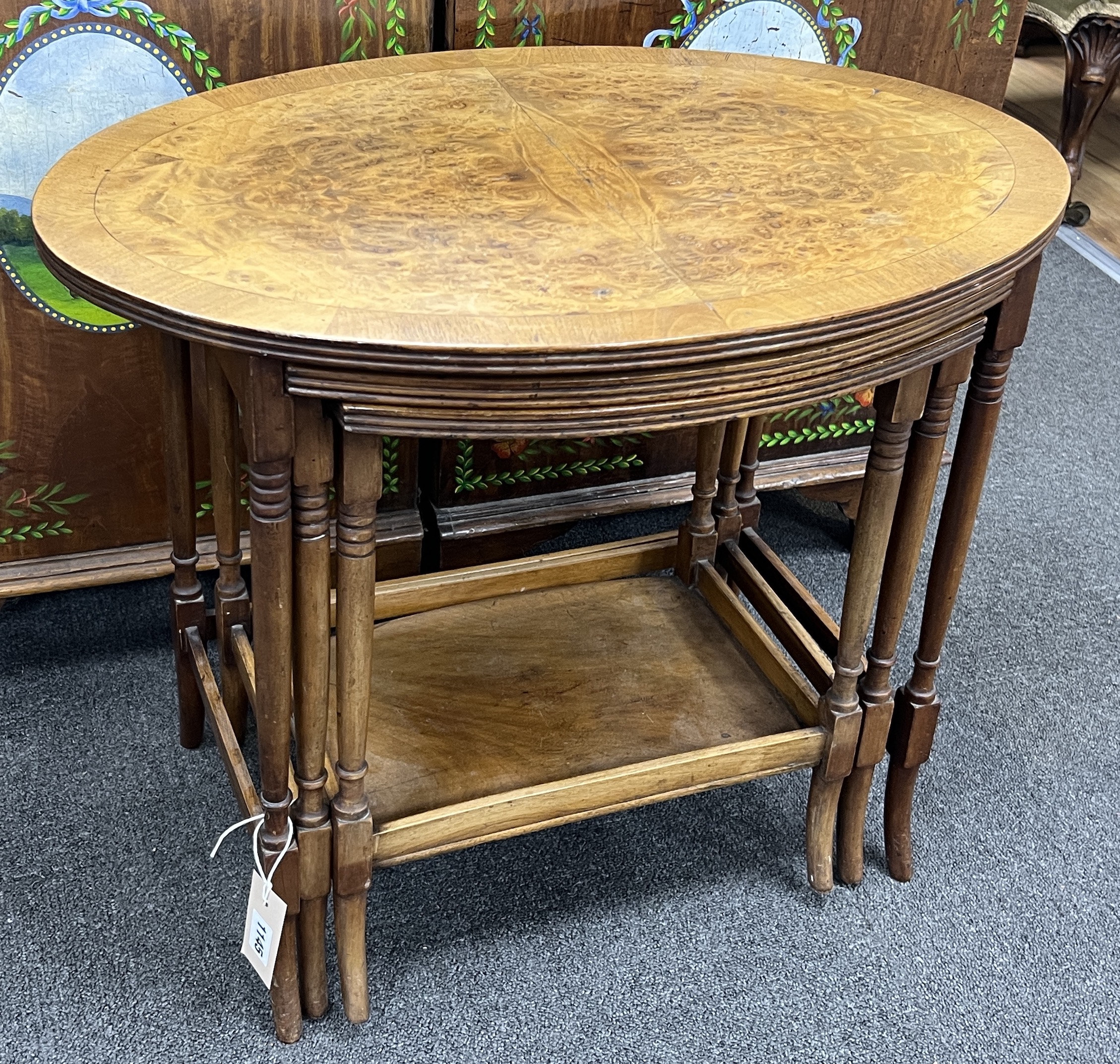 A nest of three oval burr walnut teak tea tables, width 61cm, depth 41cm, height 52cm